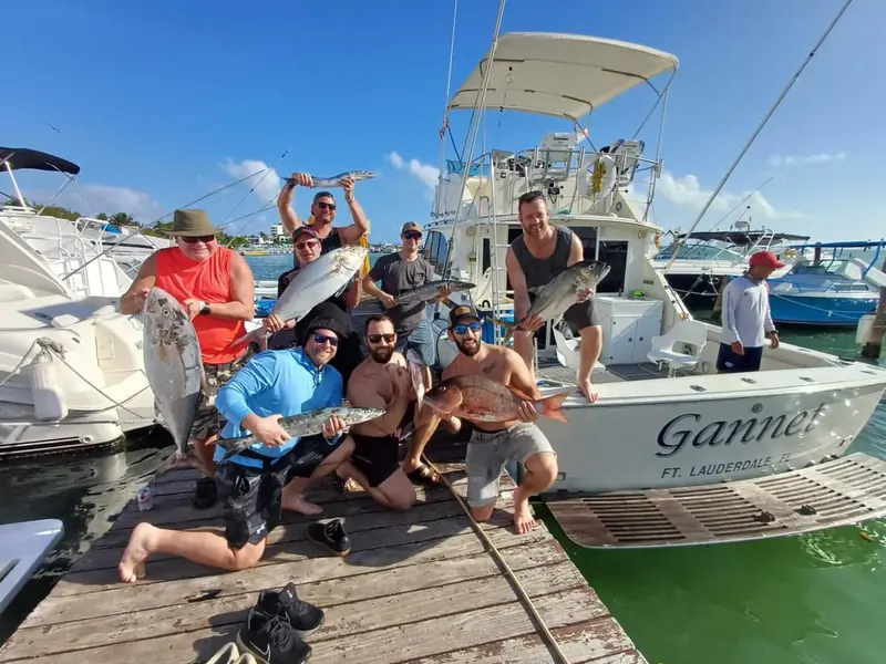 Group with their catches beside a fishing boat